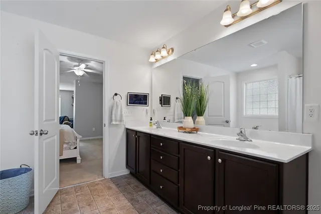 a en suite bathroom with a double vanity sink a mirror and a toilet