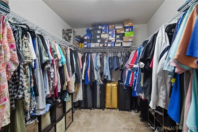 a view of walk in closet with clothes