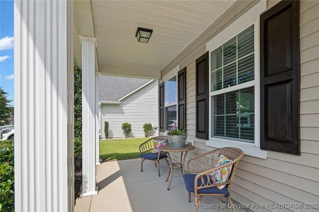 a view of a patio with table and chairs and a large window with garden view