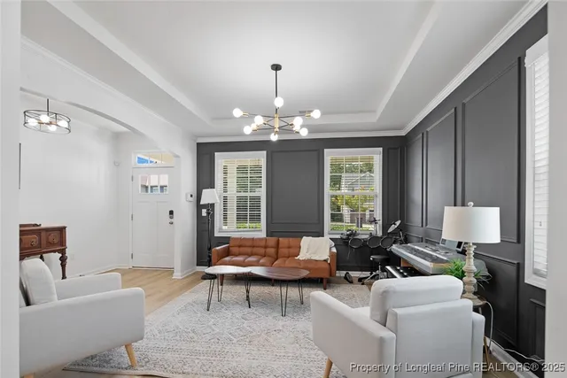 a living room with furniture chandelier and a large window