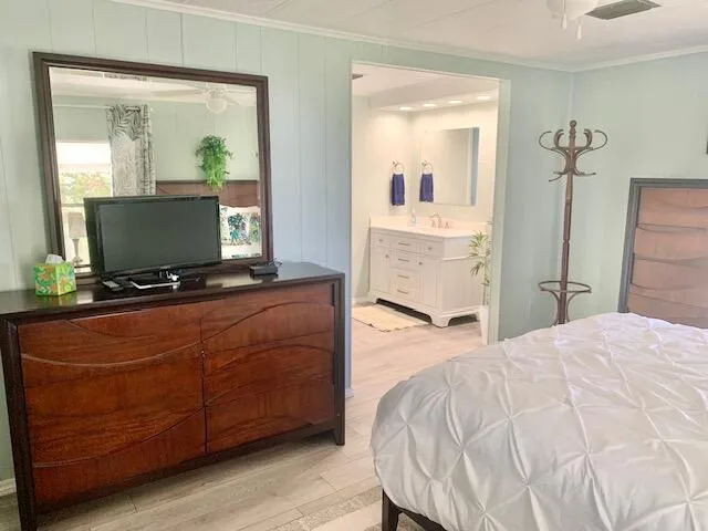 a bedroom with a bed and a mirror on dresser