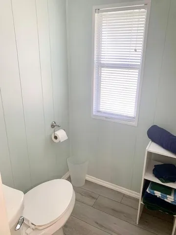 a white toilet sitting next to a window