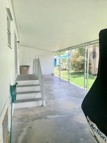 a view of an empty room with a floor to ceiling window and stairs