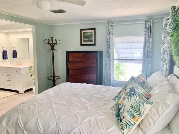 a bedroom with a bed and a mirror on dresser