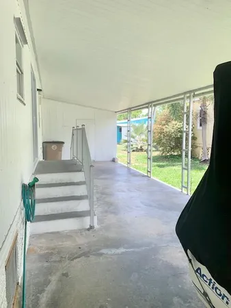 a view of a porch with furniture and floor to ceiling window