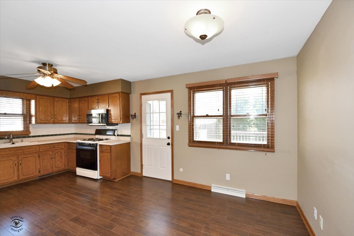 616 Northgate Road New Lenox, IL 60451 - Photo 12 of 34 a large kitchen with stainless steel appliances granite countertop a stove and a large window