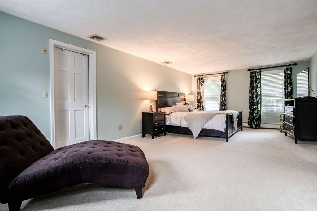 89 Shadow Oak Drive Sudbury, MA 01776 - Photo 19 of 31 a spacious bedroom with a bed and a couch