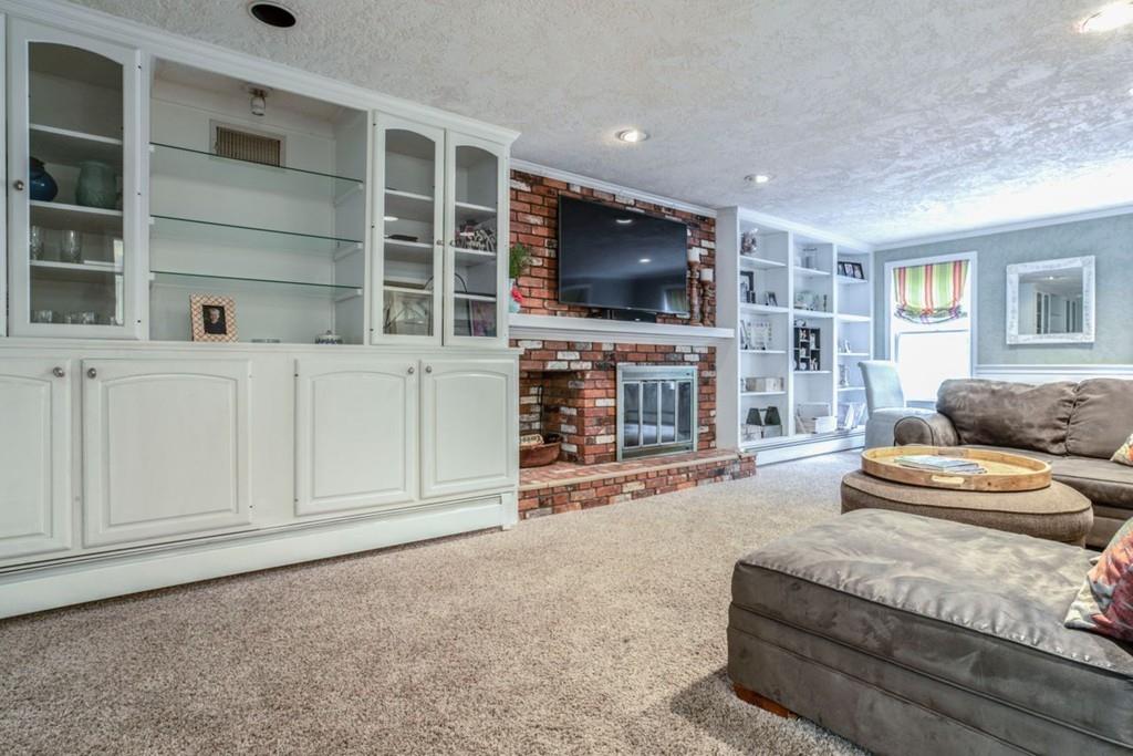 89 Shadow Oak Drive Sudbury, MA 01776 - Photo 5 of 31 a living room with furniture a flat screen tv and a fireplace