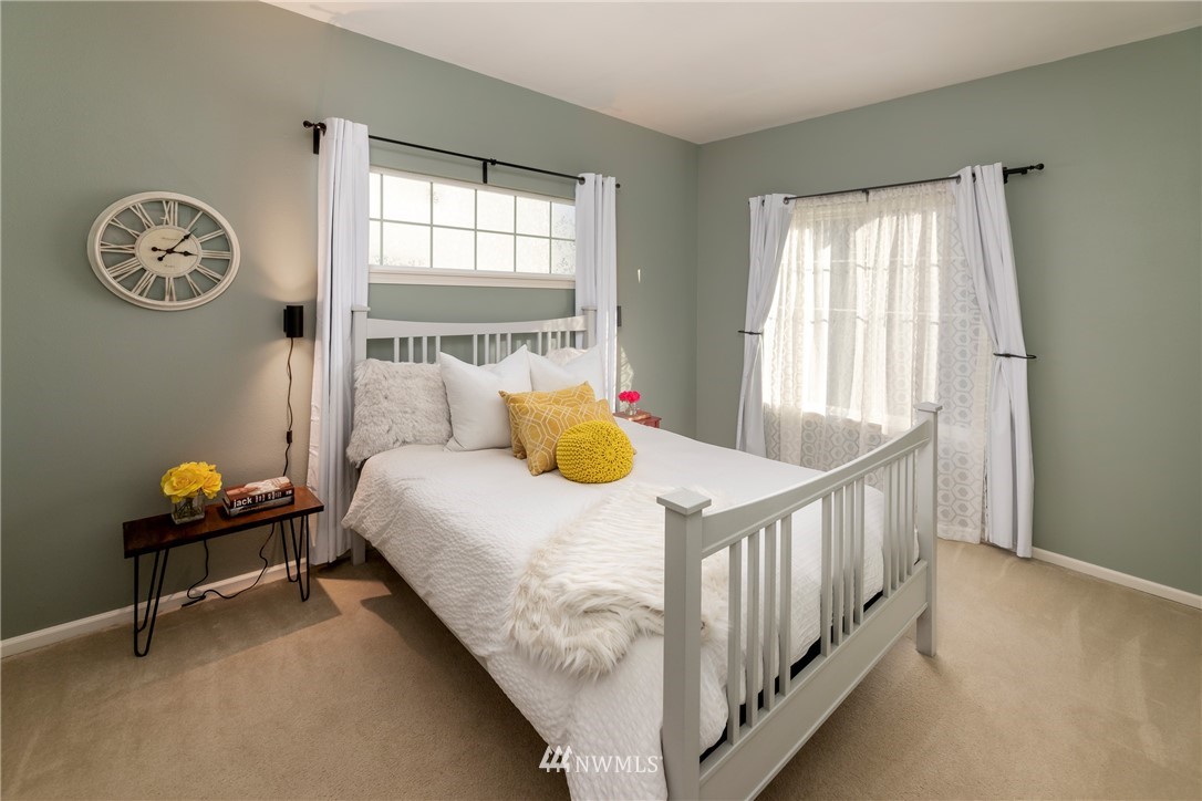 214 South 48th Street, Unit 45B Renton, WA 98055 - Photo 16 of 30 a bedroom with a bed a window and a chandelier