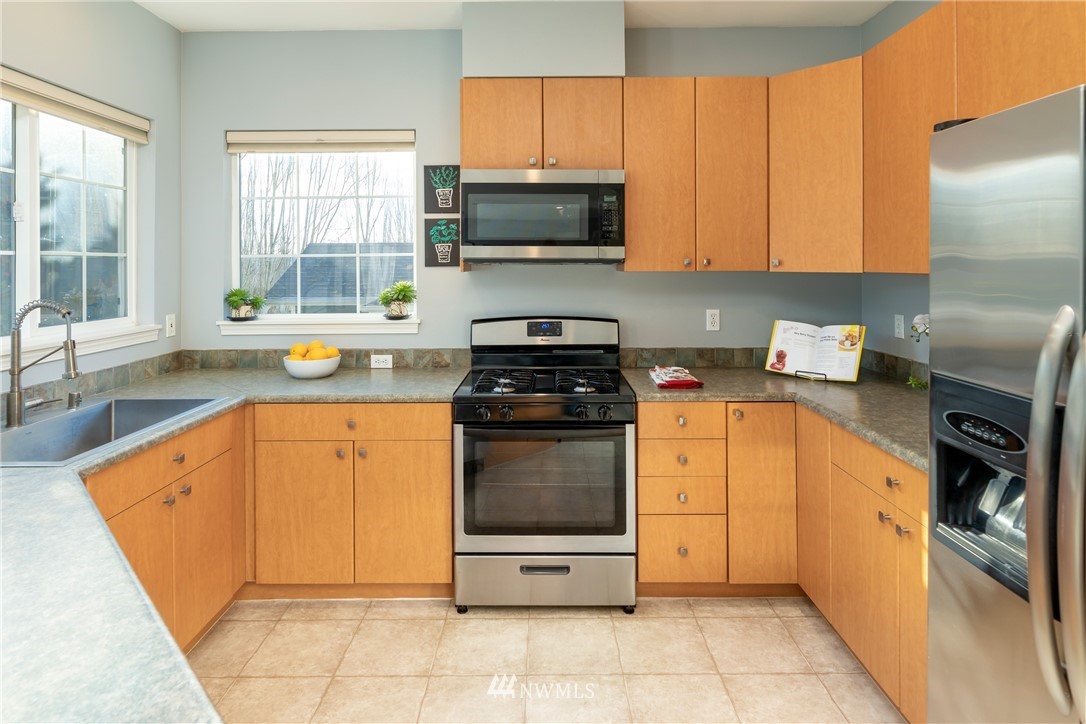 214 South 48th Street, Unit 45B Renton, WA 98055 - Photo 10 of 30 a kitchen with stainless steel appliances granite countertop a stove a sink and a microwave
