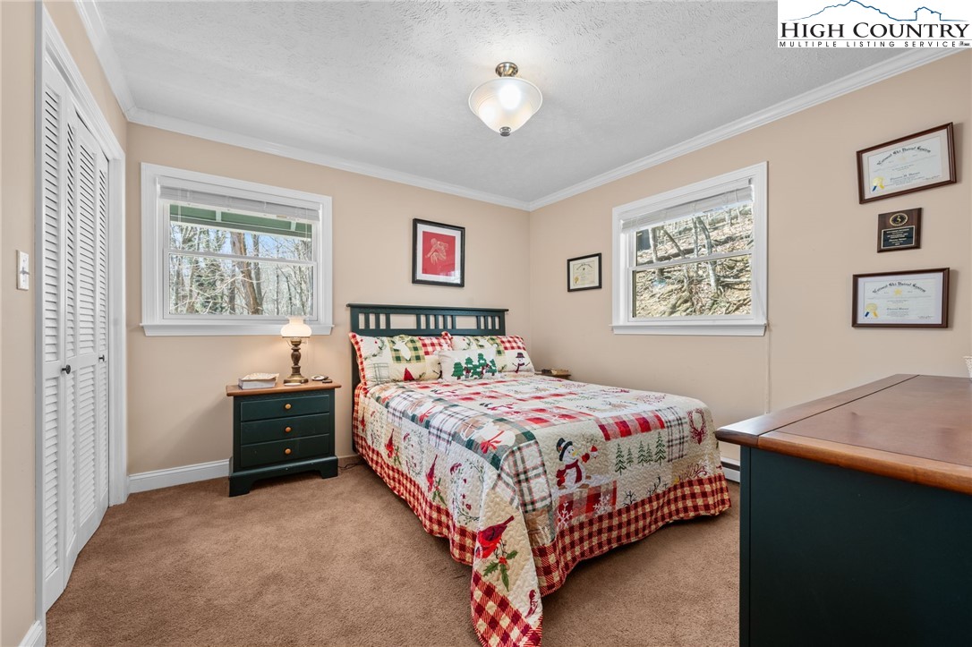 431 Cliffside Lane Seven Devils, NC 28604 - Photo 16 of 46 a bedroom with a bed and a table