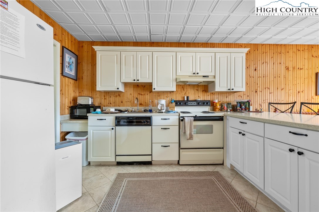 431 Cliffside Lane Seven Devils, NC 28604 - Photo 31 of 46 a kitchen with white cabinets and white appliances