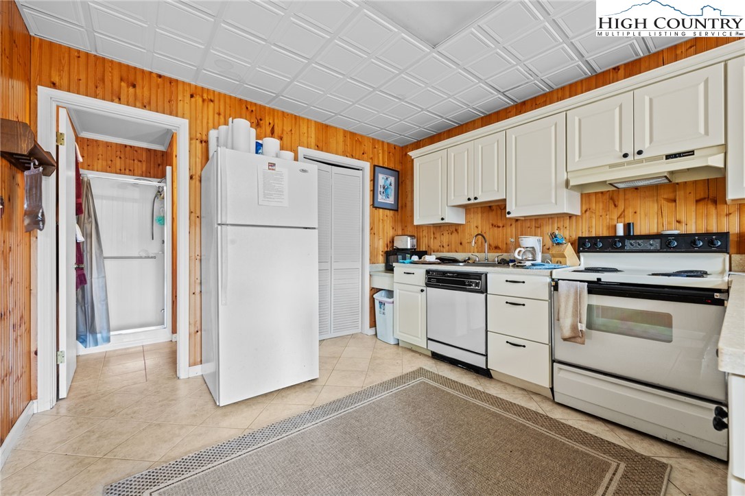 431 Cliffside Lane Seven Devils, NC 28604 - Photo 32 of 46 a kitchen with white cabinets and white appliances