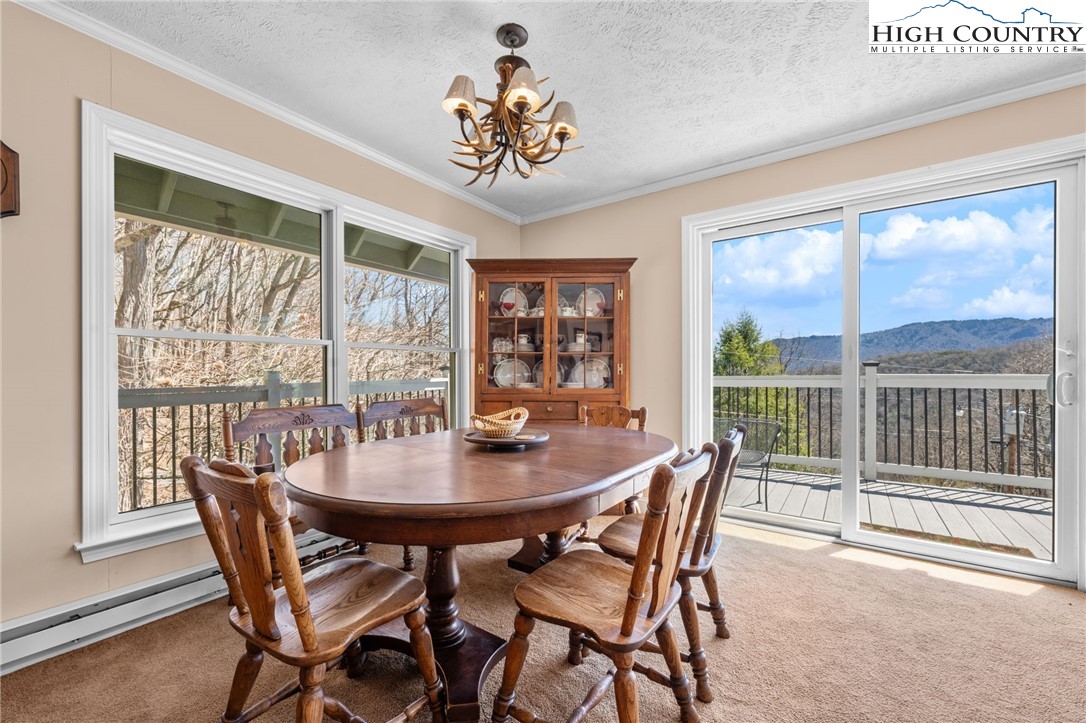 431 Cliffside Lane Seven Devils, NC 28604 - Photo 10 of 46 a dining room with furniture large windows and a chandelier