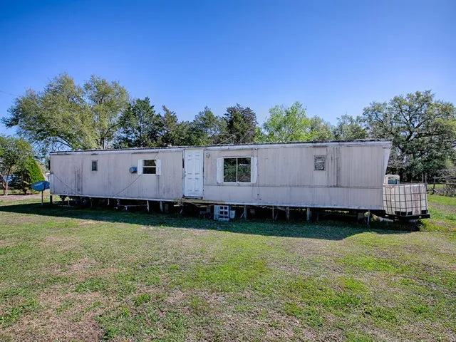 a view of house with backyard and outdoor seating
