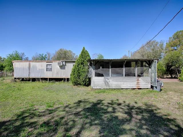 a view of a house with backyard sitting area and garden