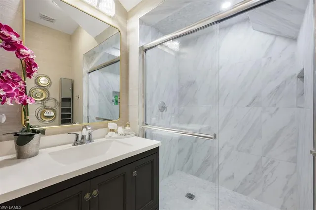 a bathroom with a granite countertop sink a shower and a mirror