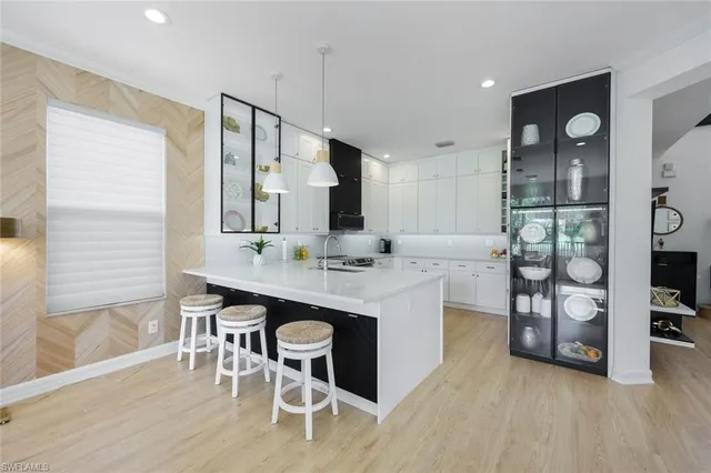 a kitchen with stainless steel appliances kitchen island a table chairs in it and wooden floors