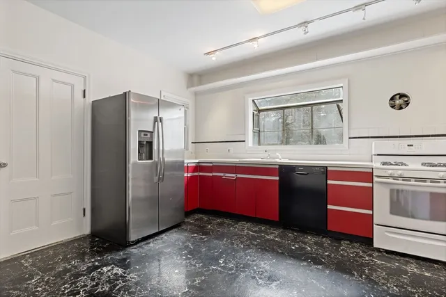 a kitchen with stainless steel appliances granite countertop a refrigerator and a stove