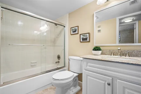 a bathroom with a granite countertop sink toilet and shower