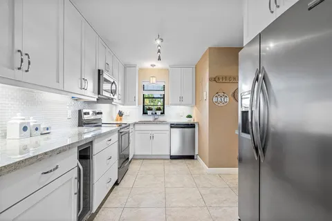 a kitchen with a sink refrigerator and cabinets