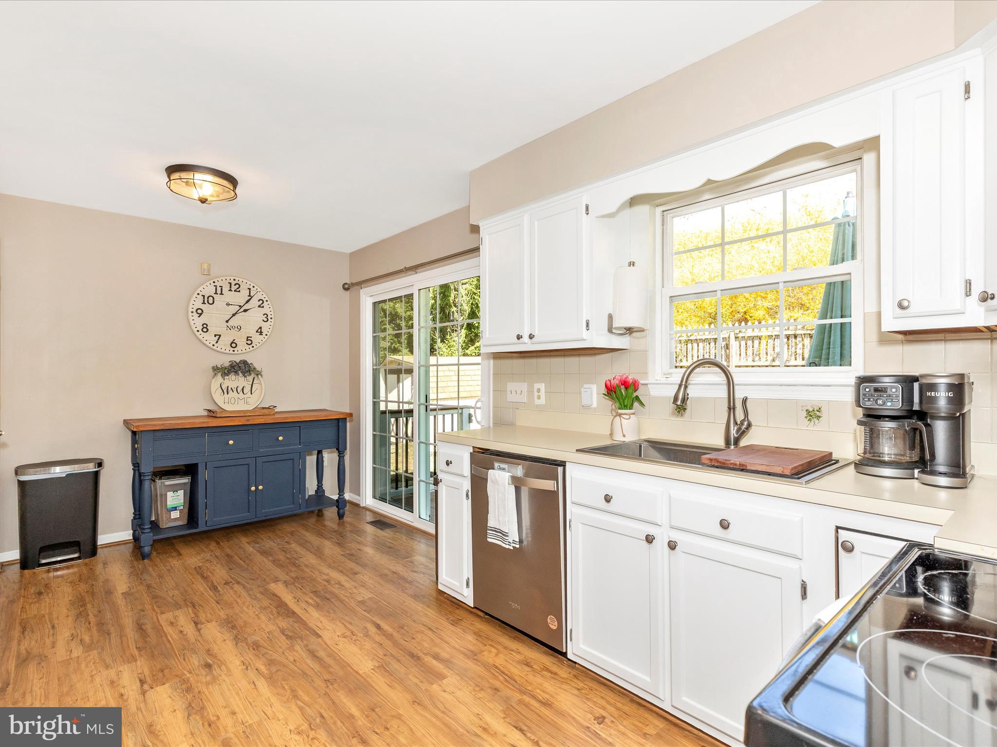 3935 Brittany Lane Hampstead, MD 21074 - Photo 18 of 55 a kitchen with stainless steel appliances granite countertop a stove a sink dishwasher and white cabinets with wooden floor