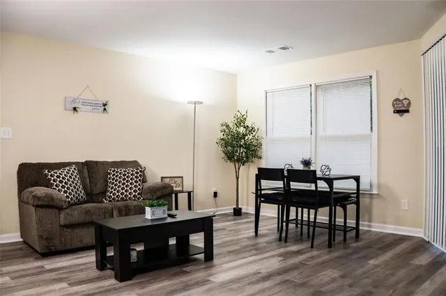 a living room with furniture potted plant and wooden floor