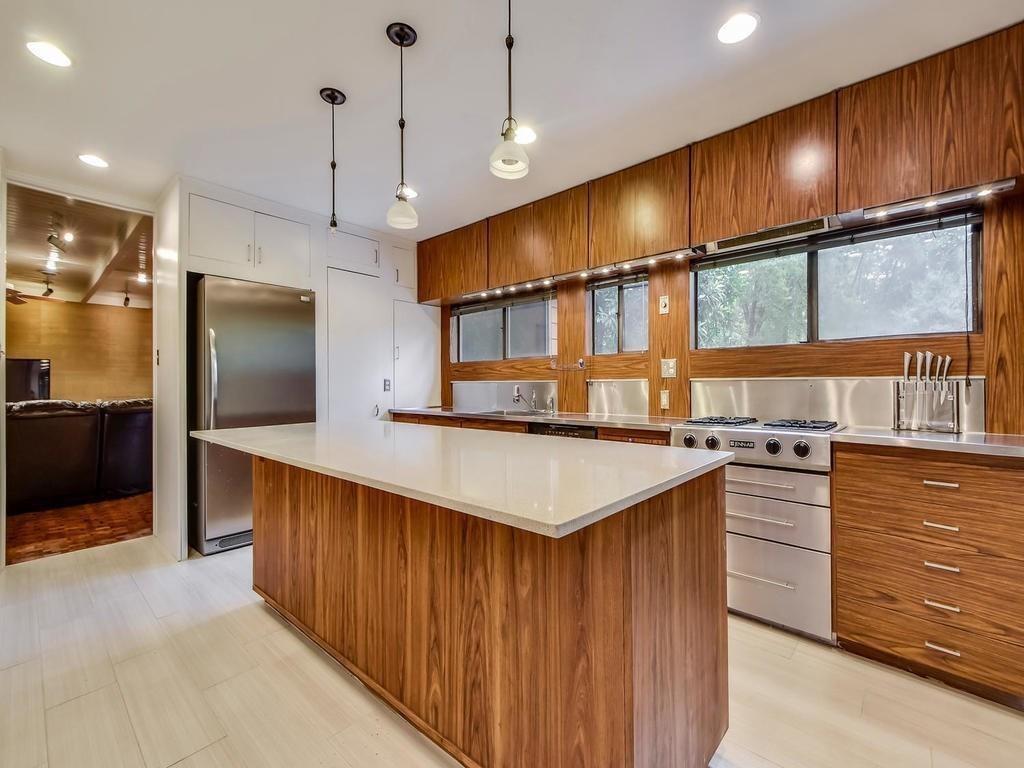 800 Leonard Street Austin, TX 78705 - Photo 11 of 31 a kitchen with kitchen island a counter top space appliances and a ceiling fan