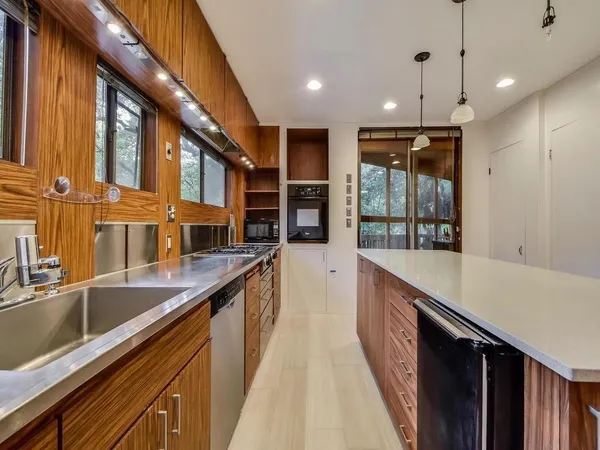 a kitchen with kitchen island a sink stove and refrigerator