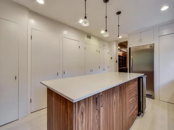 a kitchen with kitchen island a counter top space appliances and a ceiling fan