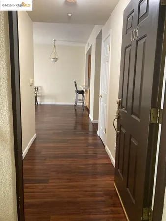 a view of a hallway with wooden floor and staircase