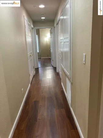 a view of a hallway with wooden floor