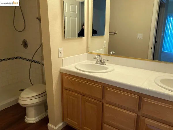 a bathroom with a granite countertop sink toilet and shower