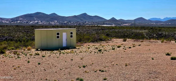 a view of a house with a yard and mountain view in back
