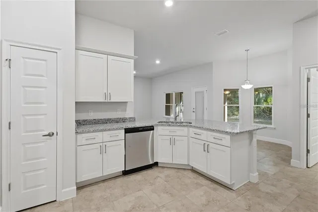 a large room with stainless steel appliances kitchen island granite countertop a large counter top and sink