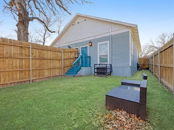 a view of a backyard with wooden fence and a bench