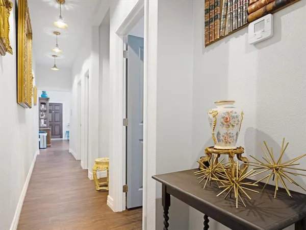 a view of a hallway with furniture and wooden floor