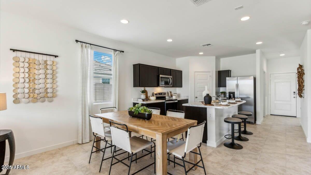 5447 East Axle Lane San Tan Valley, AZ 85140 - Photo 7 of 16 a kitchen with a dining table cabinets and appliances