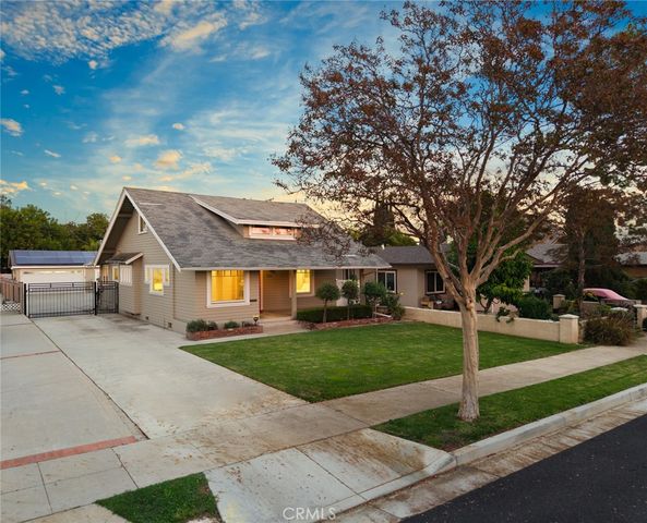 a view of a big house with a big yard and large tree