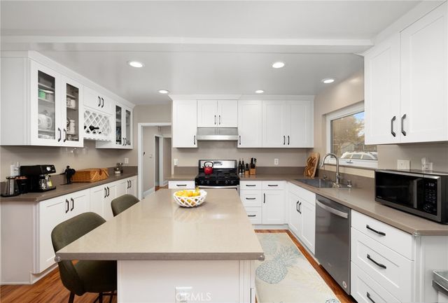 a kitchen with a sink a stove and cabinets