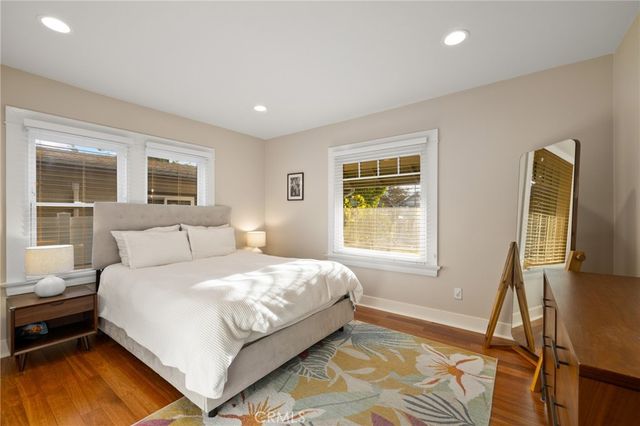 a bedroom with a bed flat screen tv and next to a window