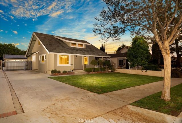 a front view of a house with a yard and trees