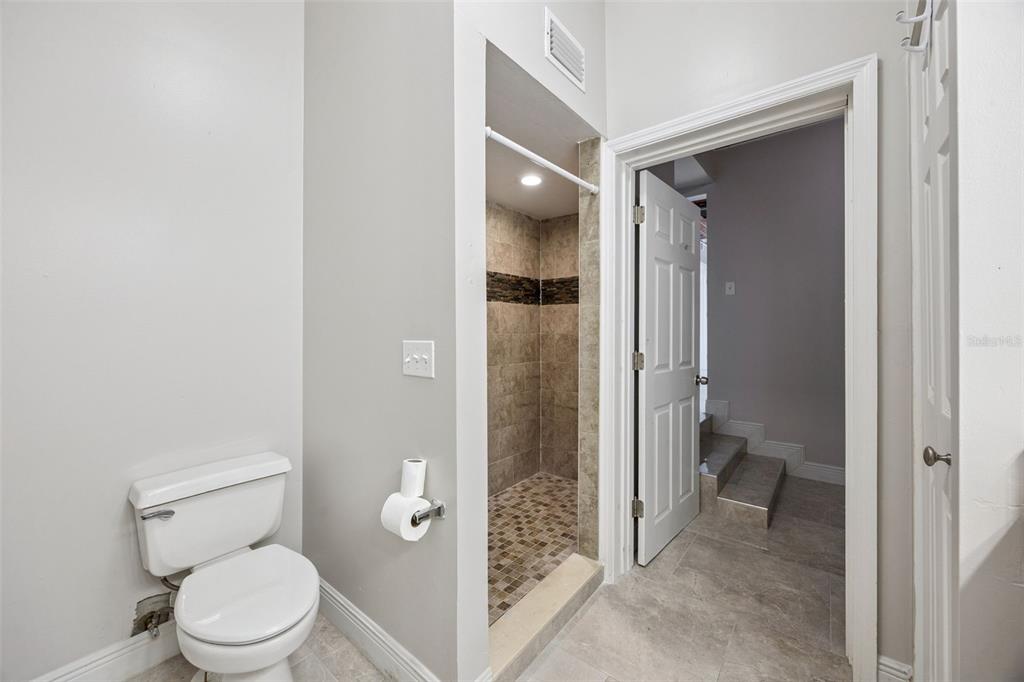 700 9th Street St. Cloud, FL 34769 - Photo 27 of 78 a bathroom with a granite countertop toilet a sink and a mirror