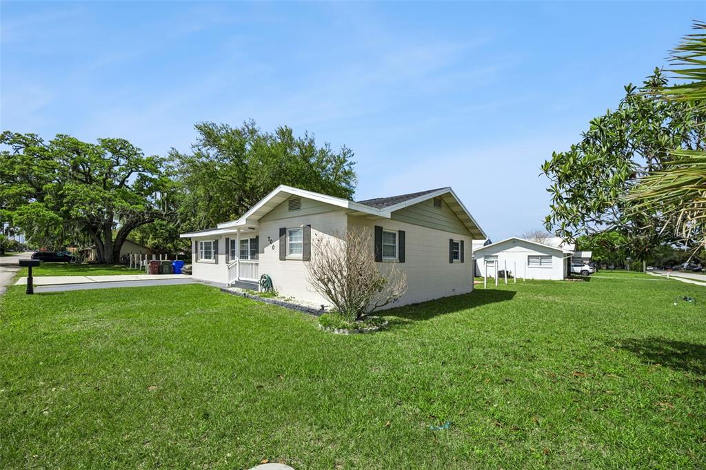 700 9th Street St. Cloud, FL 34769 - Photo 53 of 78 a house that is sitting in the grass with large trees and plants