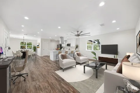 a living room with furniture kitchen view and a flat screen tv