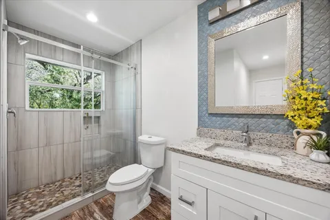 a bathroom with a granite countertop sink toilet and shower