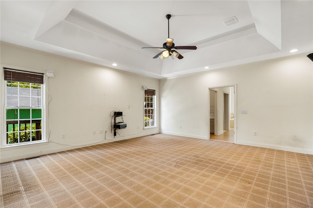 135 Sunset Bay Boulevard Seneca, SC 29672 - Photo 23 of 50 A spacious primary bedroom features tray ceilings and ample light from multiple windows.