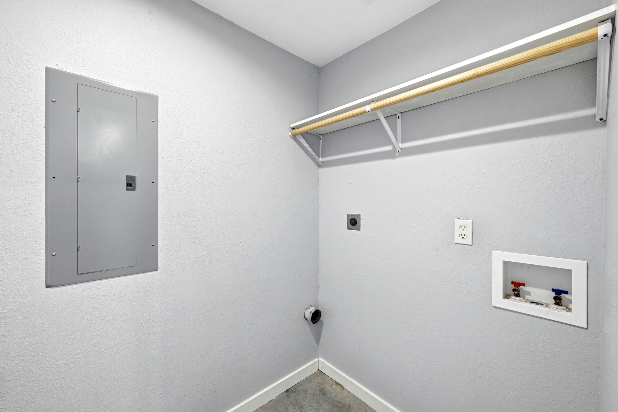 4001 Barth Road Lockhart, TX 78644 - Photo 26 of 38 A dedicated laundry space features concrete flooring and an integrated storage shelf.
