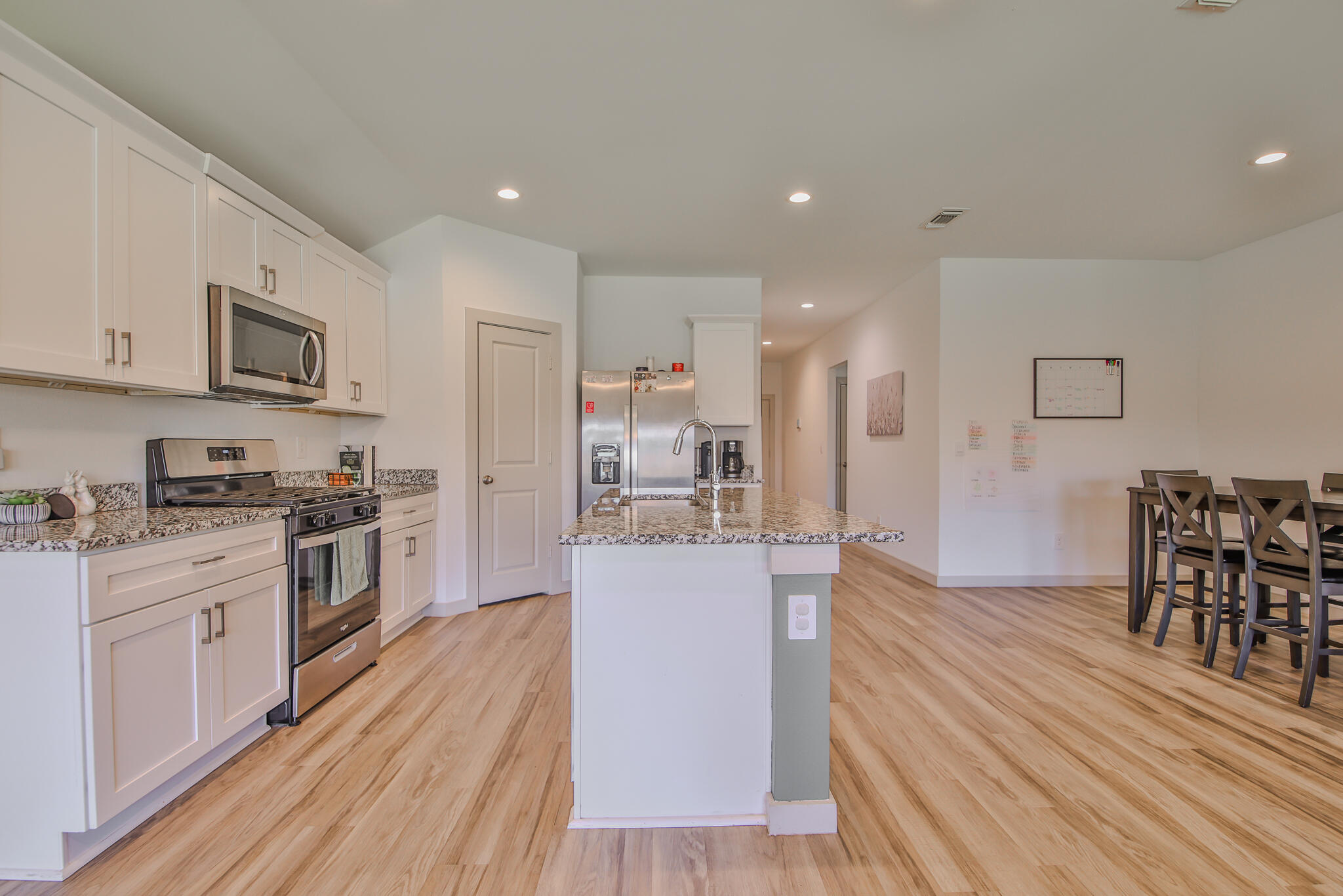 7406 9th Street Lubbock, TX 79416 - Photo 30 of 54 a large kitchen with stainless steel appliances granite countertop a lot of counter space and wooden floor