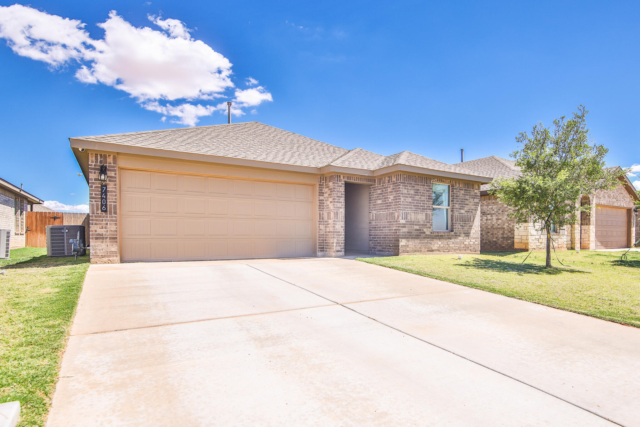 7406 9th Street Lubbock, TX 79416 - Photo 3 of 54 a front view of a house with a yard and garage